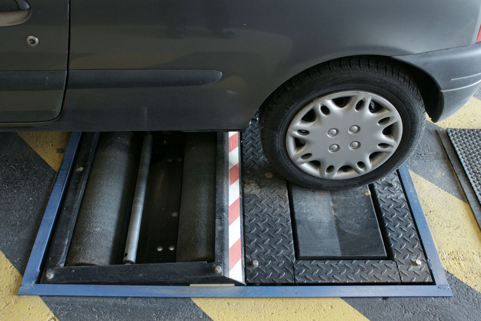 Les roues d'une voiture positionnées sur un banc de contrôle des liaisons au sol.