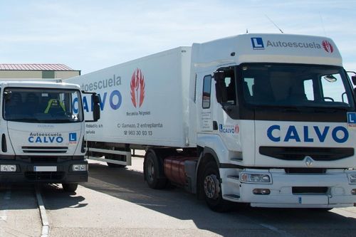 Dos camiones refrigerados blancos de CALVO aparcados uno al lado del otro en un aparcamiento