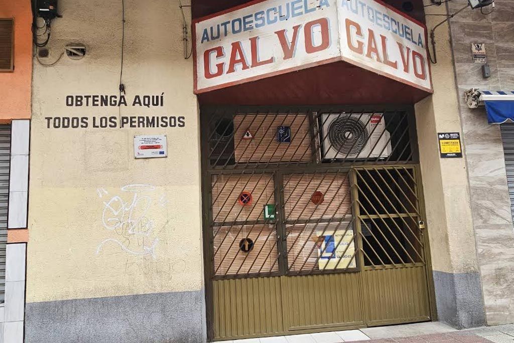 Fachada de la autoescuela CALVO con un cartel que dice: «Obtenga aquí todos los permisos»