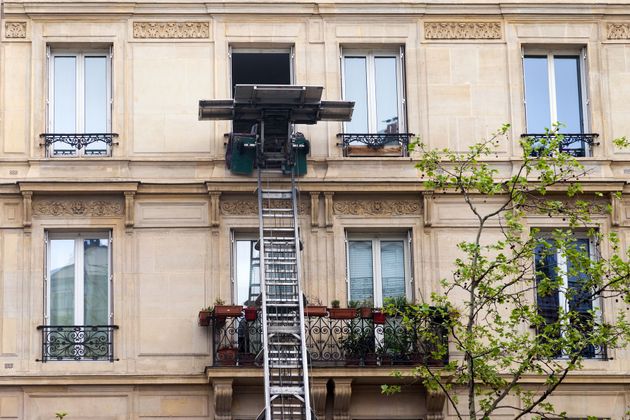 Monte-meubles en fonctionnement sur une façade d'immeuble