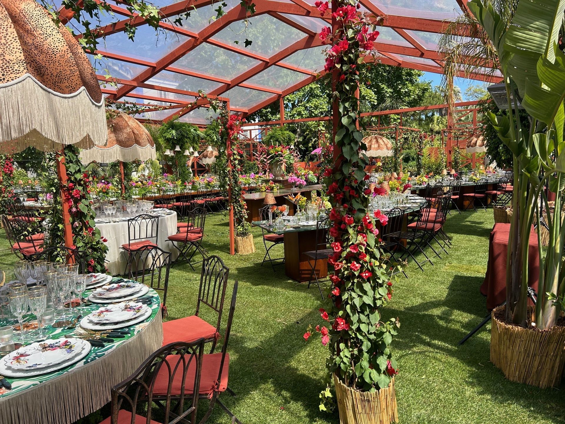 Uma mesa e cadeiras estão sob uma tenda em um campo.