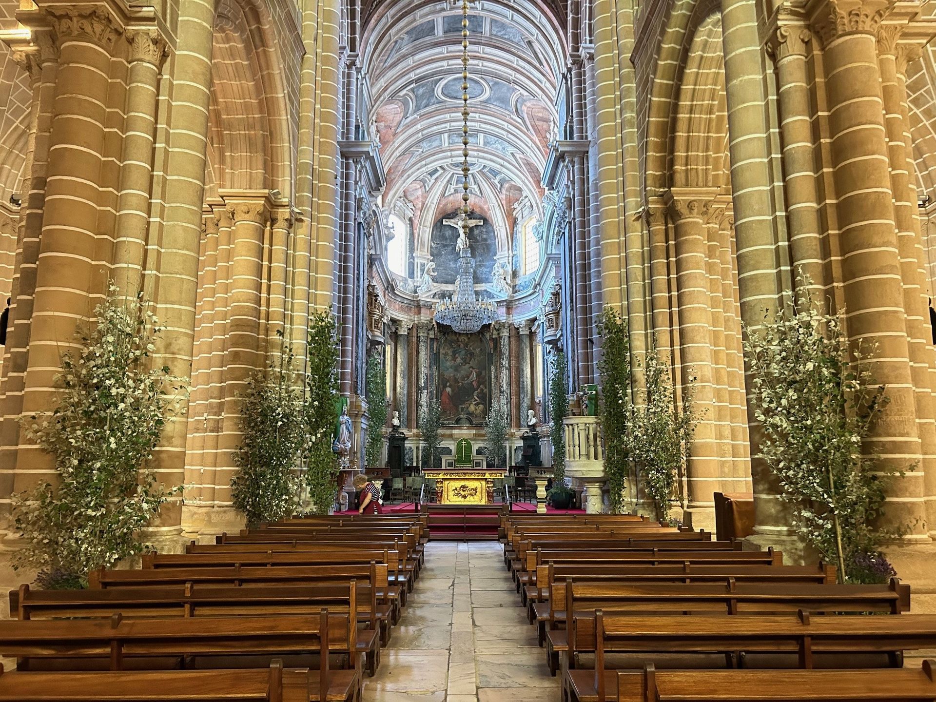 O interior de uma igreja com bancos e colunas de madeira.