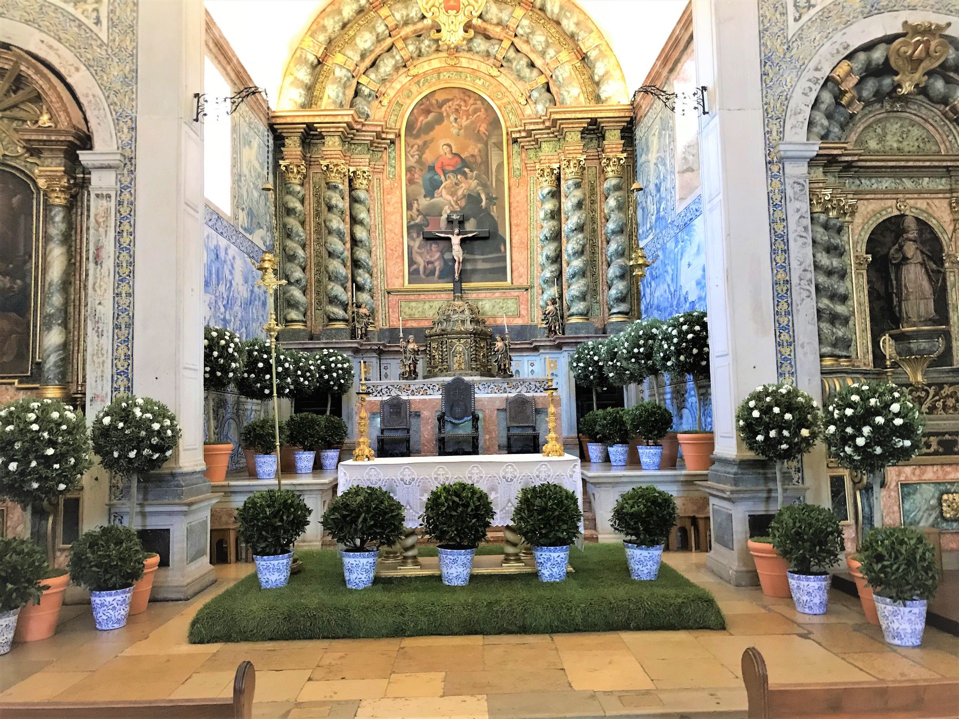 O interior de uma igreja decorada com plantas e flores em vasos