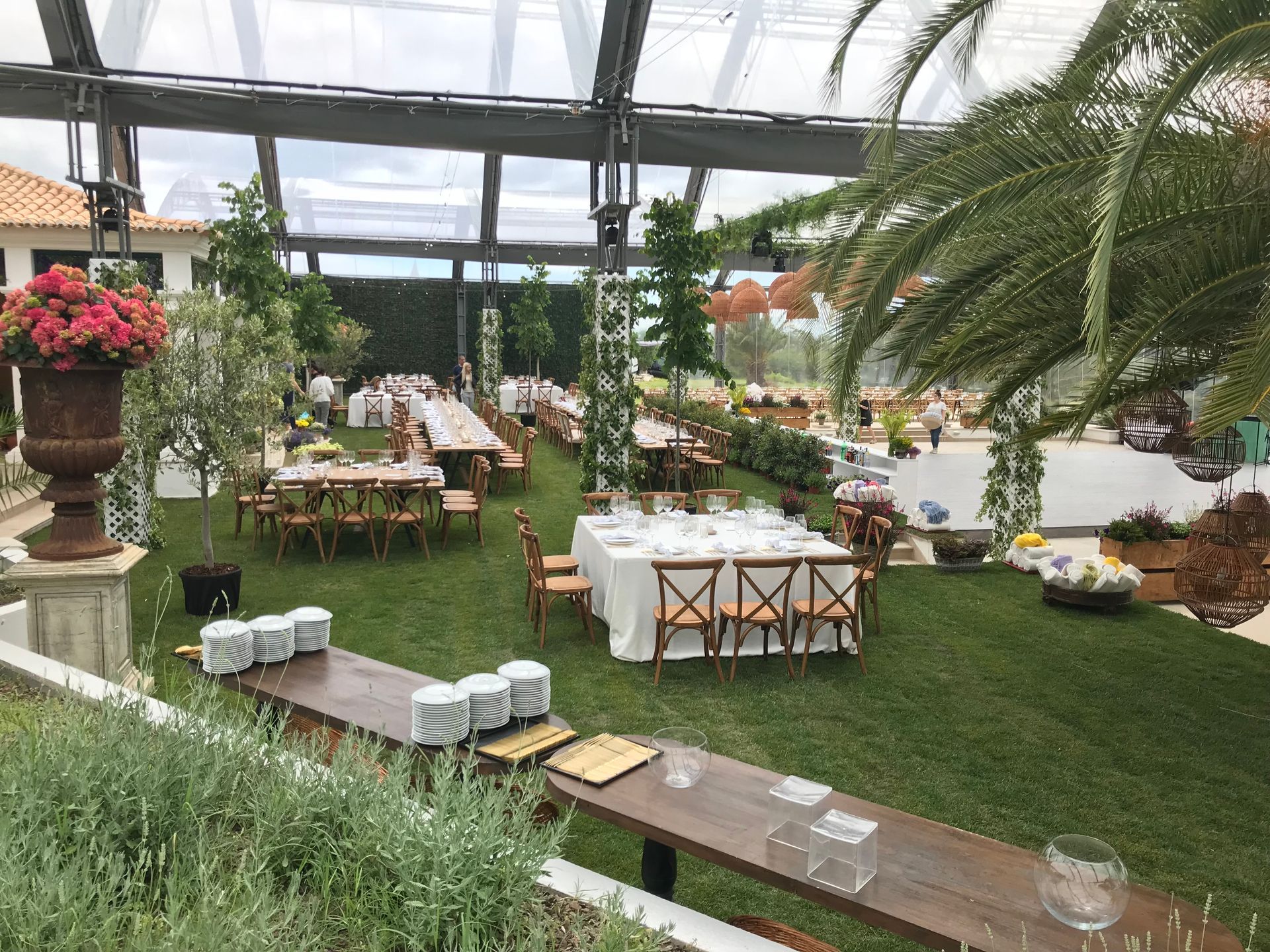 Um grande gramado com mesas e cadeiras preparadas para uma recepção de casamento.