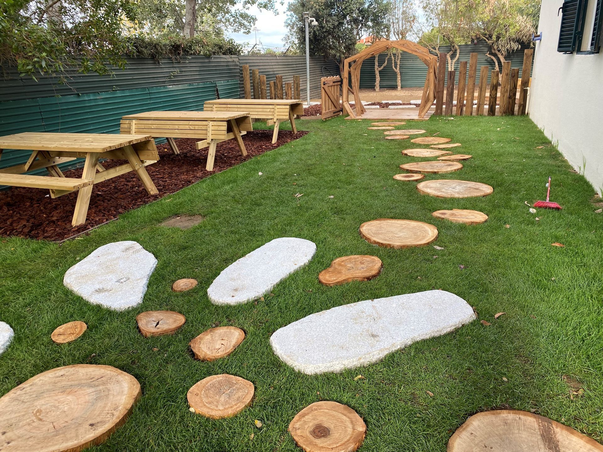 Uma área de piquenique com mesas e bancos de madeira na grama.
