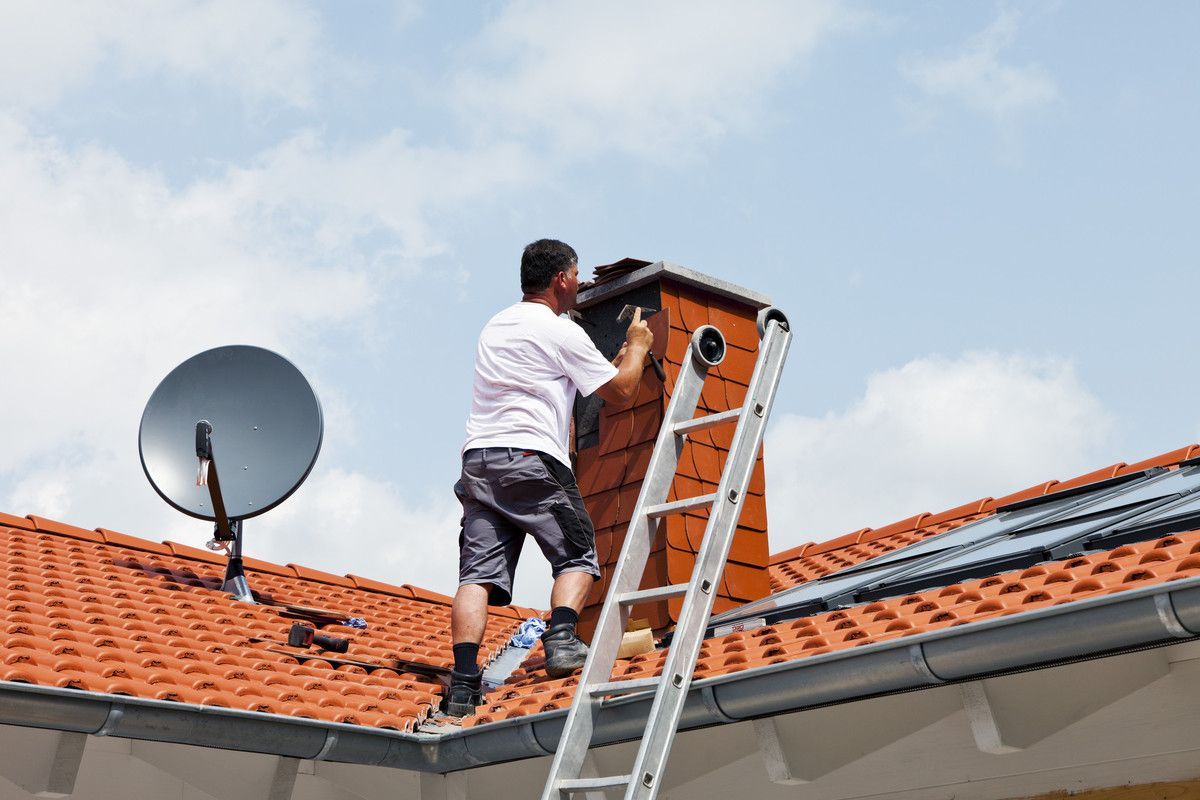 Un homme installe une cheminée de toit