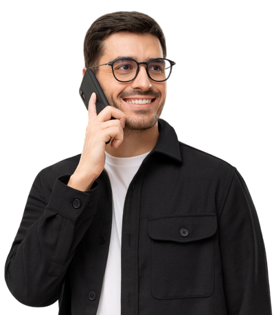 Un homme portant des lunettes sourit en parlant au téléphone. Il porte une chemise noire boutonnée sur un t-shirt blanc.