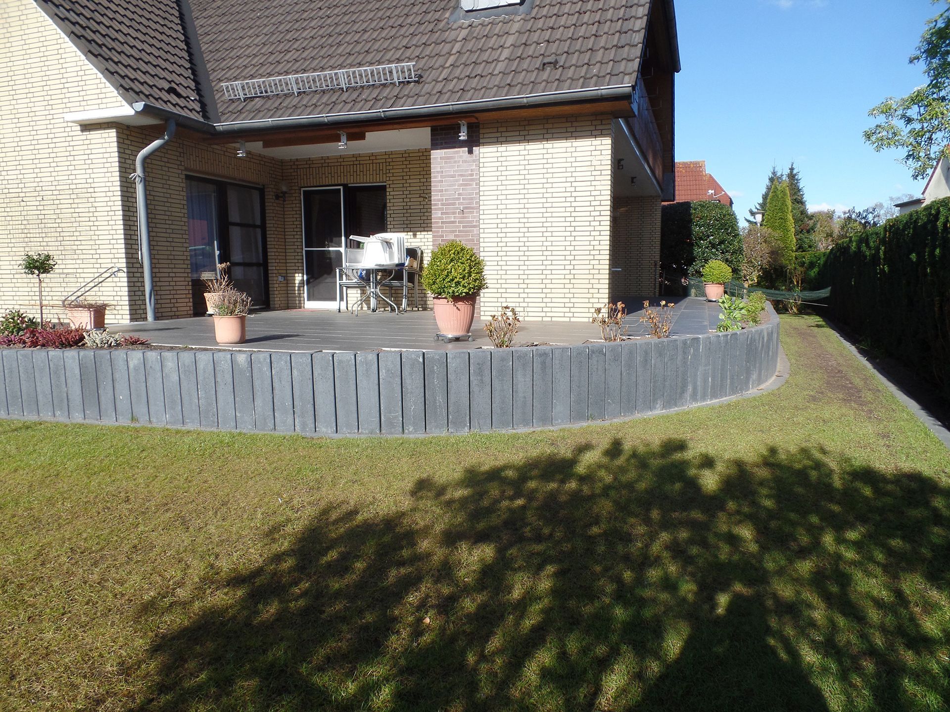 Ein Haus mit einer Terrasse und einem Zaun davor