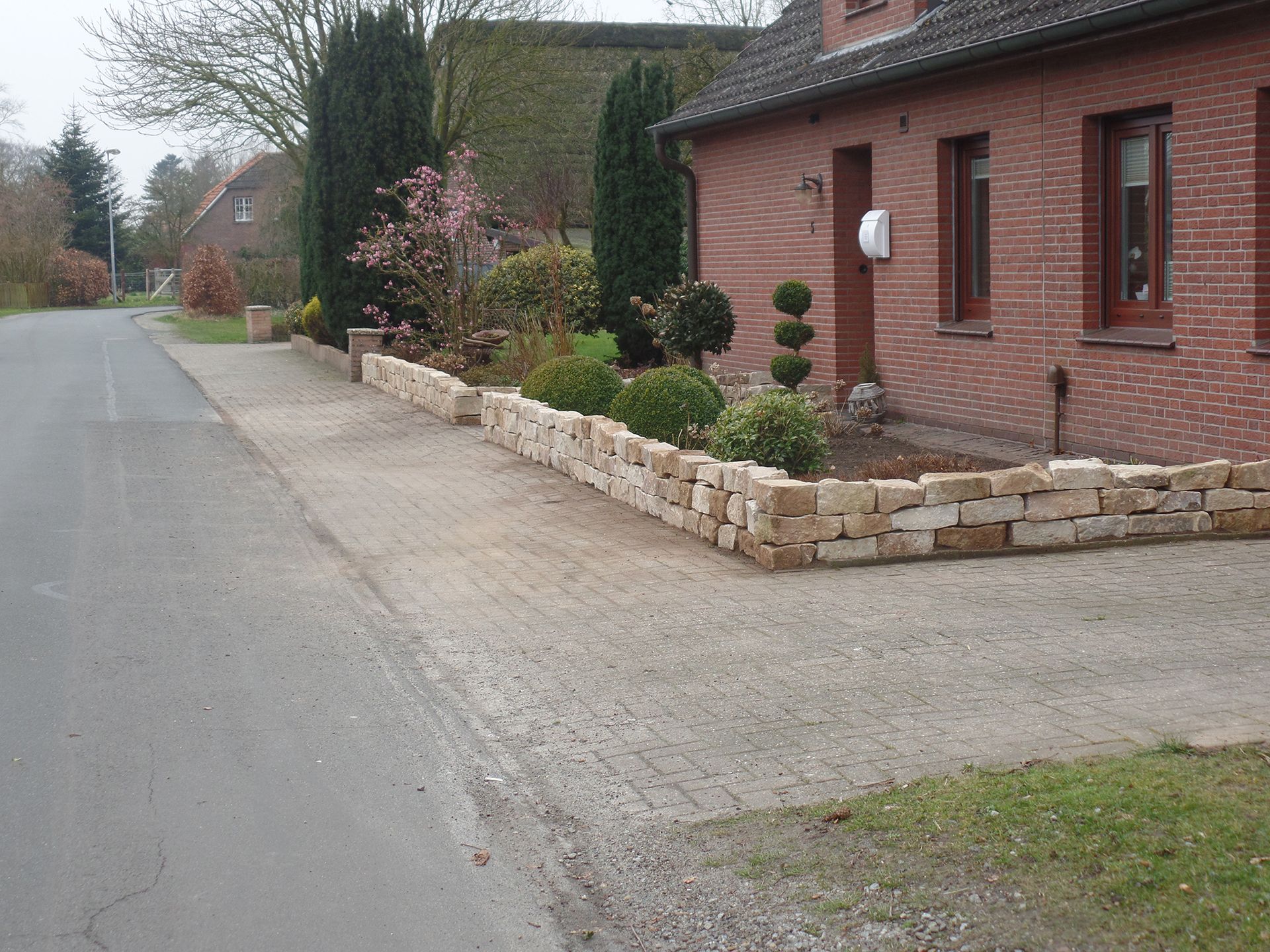 Ein Backsteinhaus mit einer Steinmauer davor
