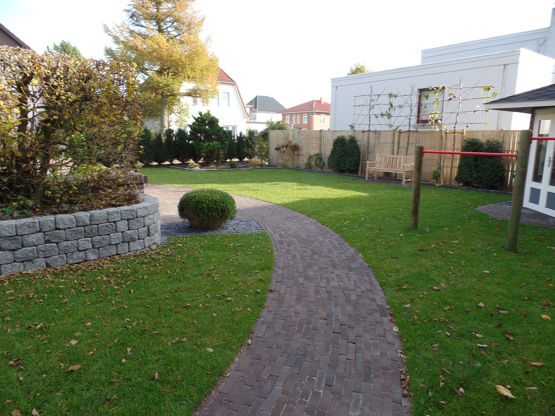 Ein Ziegelweg durch einen üppigen grünen Hof