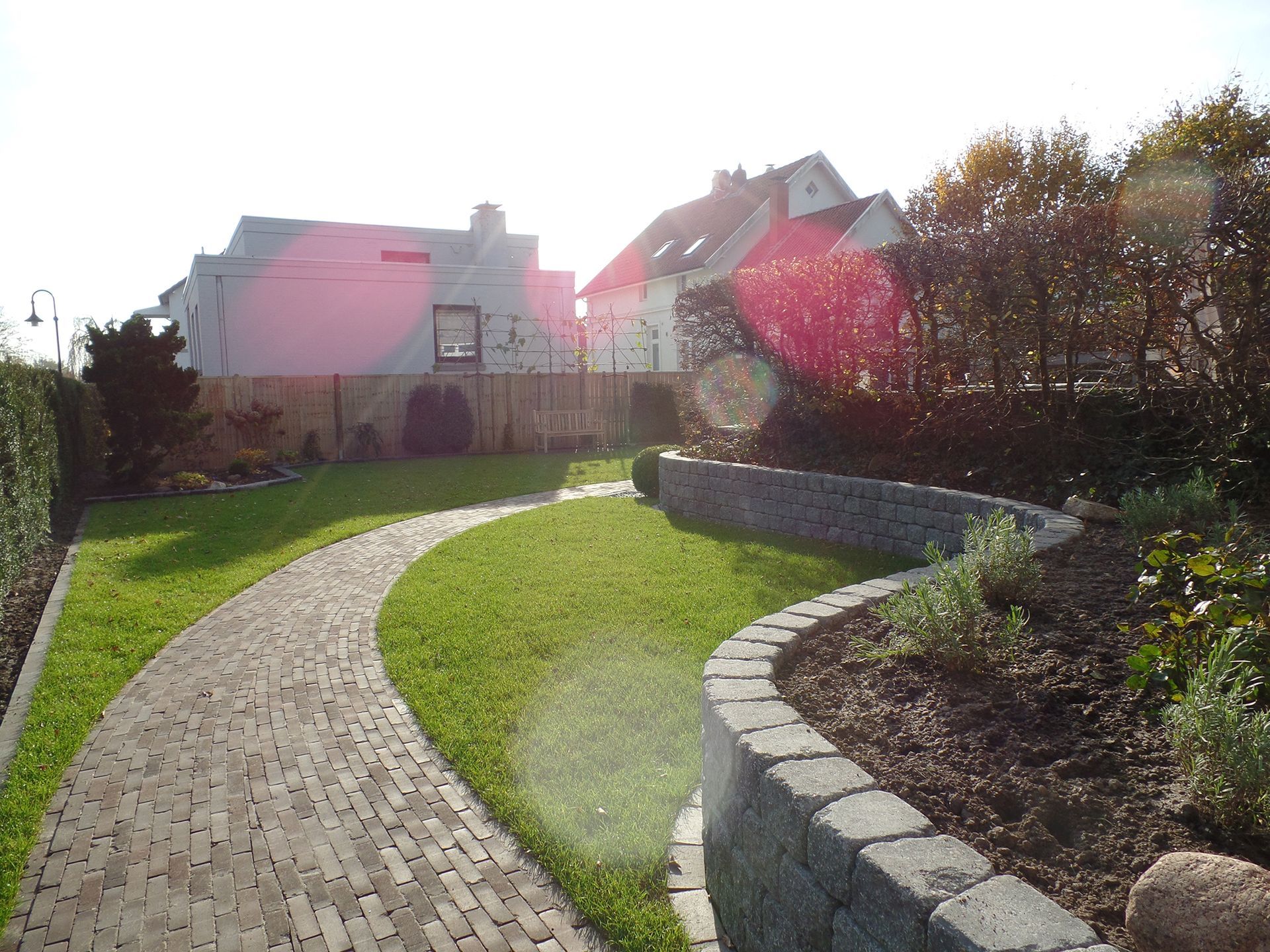 Ein Ziegelweg durch einen üppigen grünen Garten