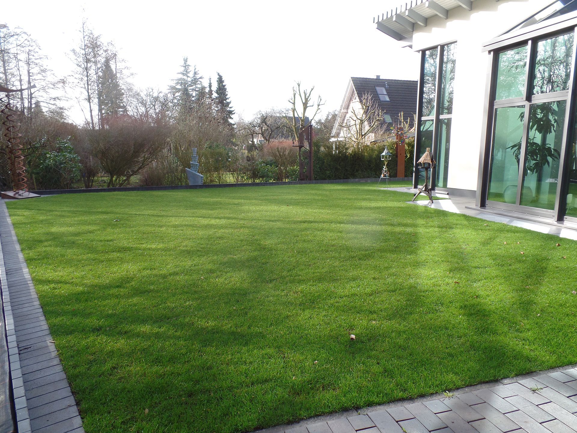 Ein großer üppiger grüner Rasen vor einem Haus