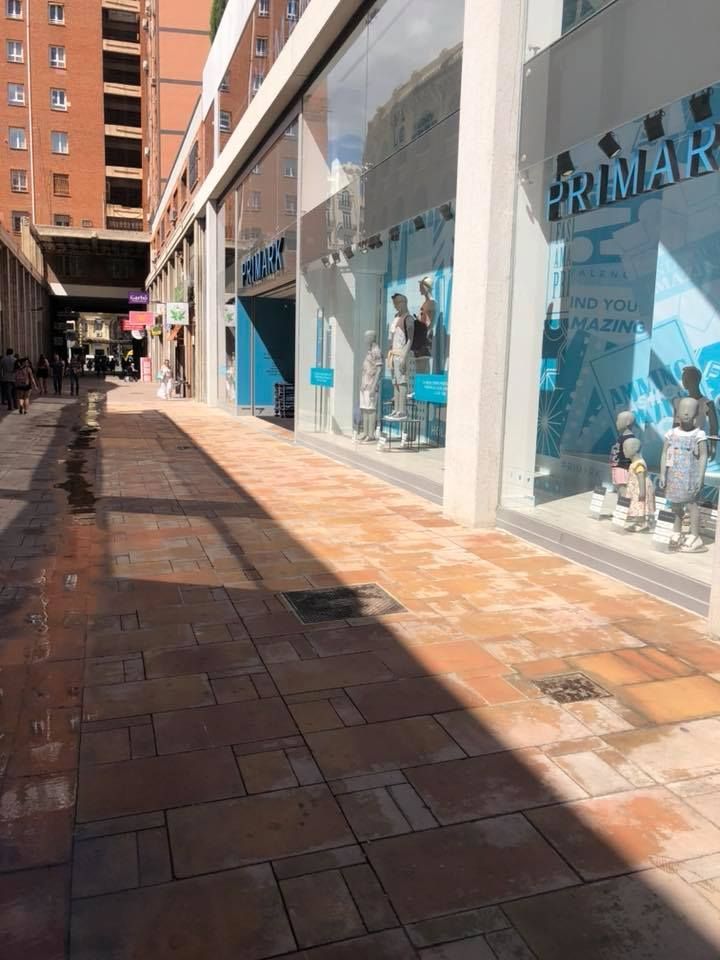 Suelo mojado de una calle estrecha comercial