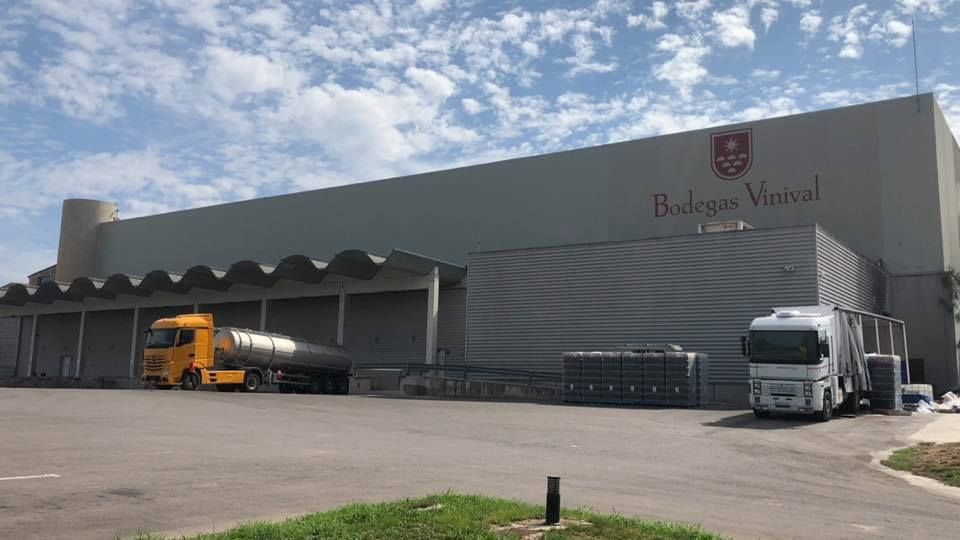 Un gran edificio gris tipo almacén con la etiqueta 
