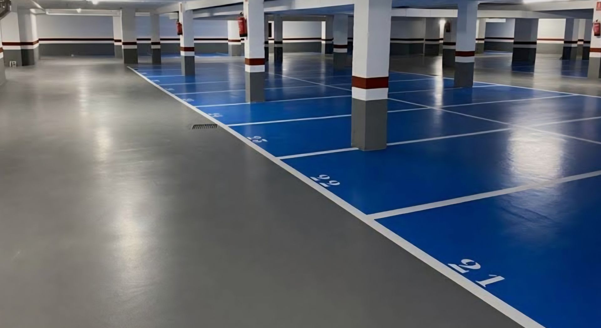 suelo garaje pintado los aparcamientos de azul oscuro y el suelo común de color gris oscuro y brillante