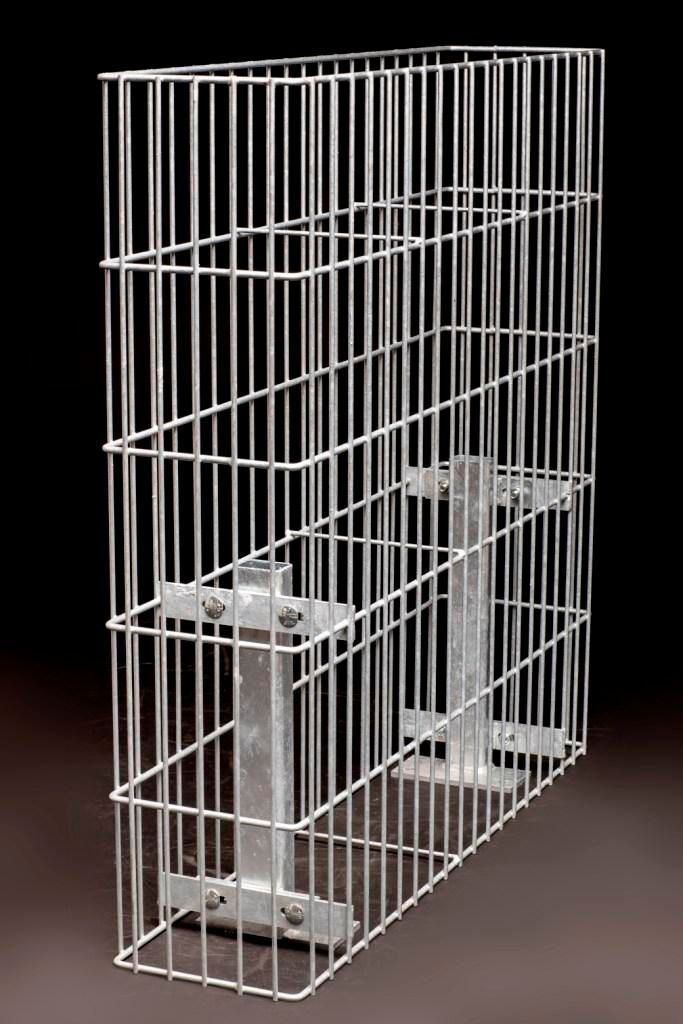 Ein rechteckiger Metalldrahtkäfig mit vertikalen und horizontalen Stäben. Im Käfiginneren befinden sich zwei Metallpfosten, die mit Klammern befestigt sind.
