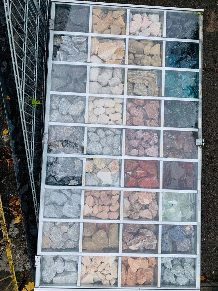 Vitrine mit 30 Fächern, die jeweils verschiedenfarbige Felsen und Steine für die Landschaftsgestaltung enthalten.