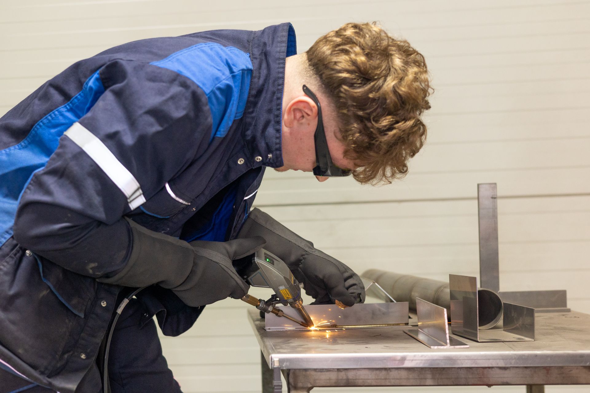 In einem Lagerhaus liegt ein Förderband aus Edelstahl auf einer Holzpalette.