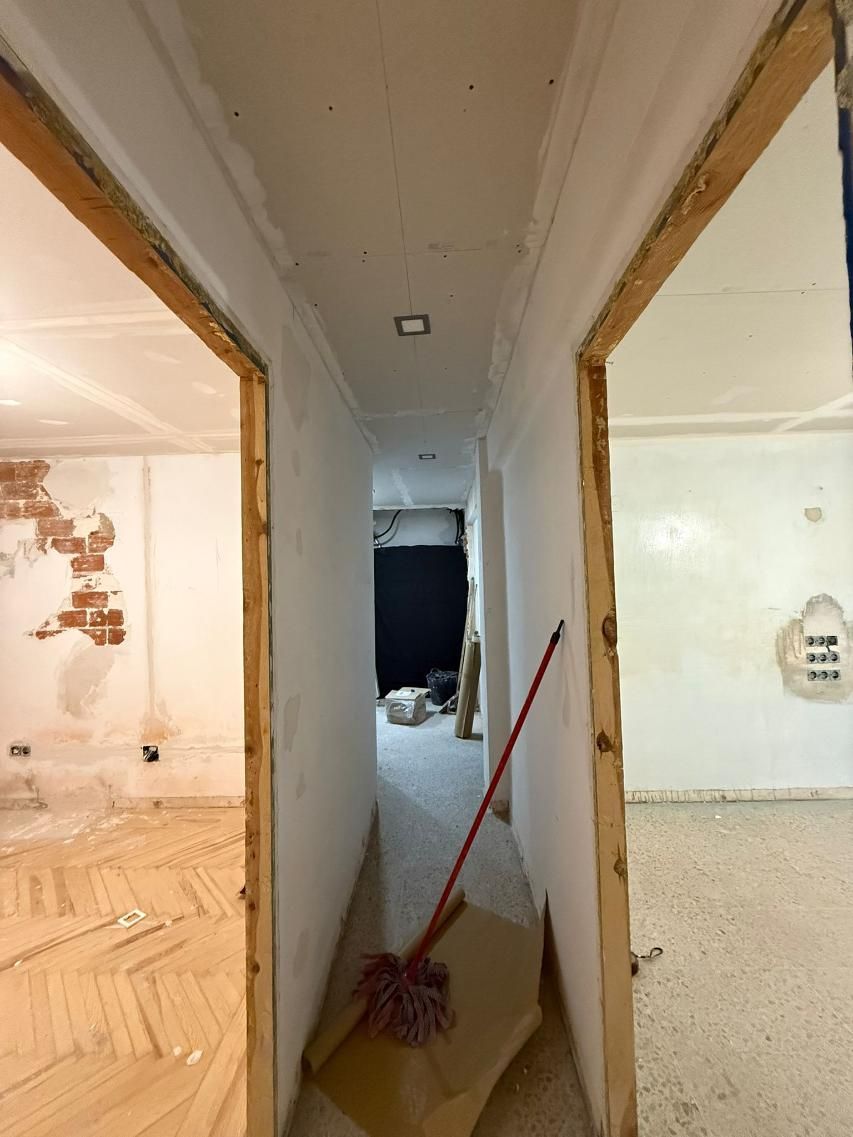 Pasillo estrecho con puertas a ambos lados, en construcción.
