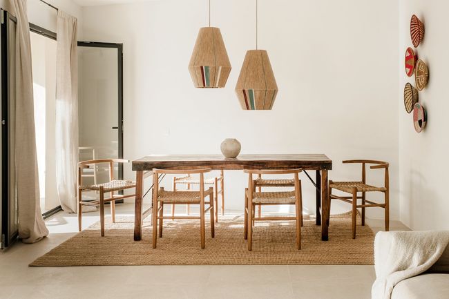 Un comedor con una mesa y sillas y una alfombra.