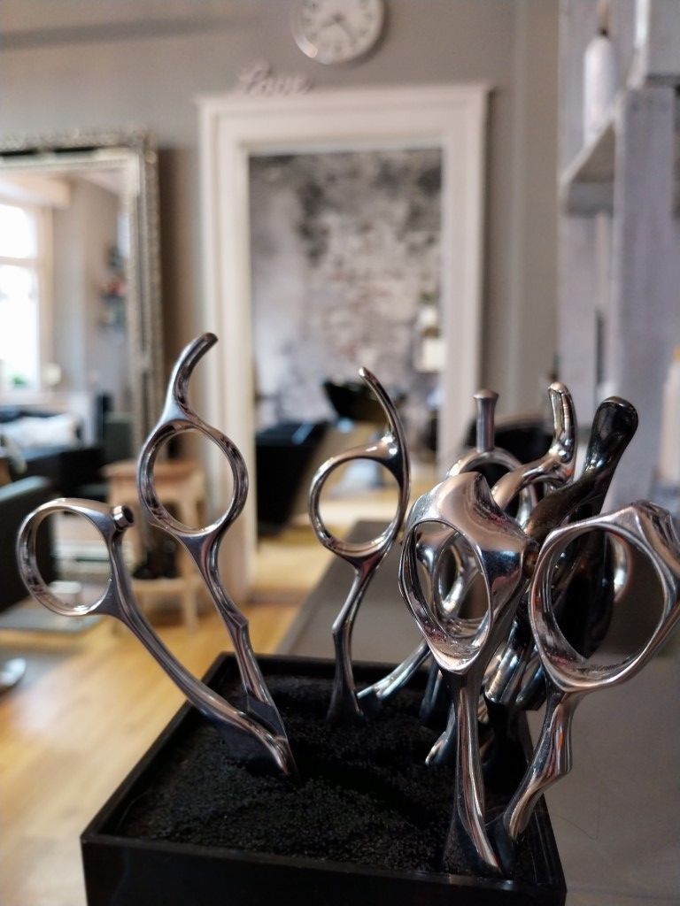 Eine Frau lässt sich von einem Friseur die Haare machen.