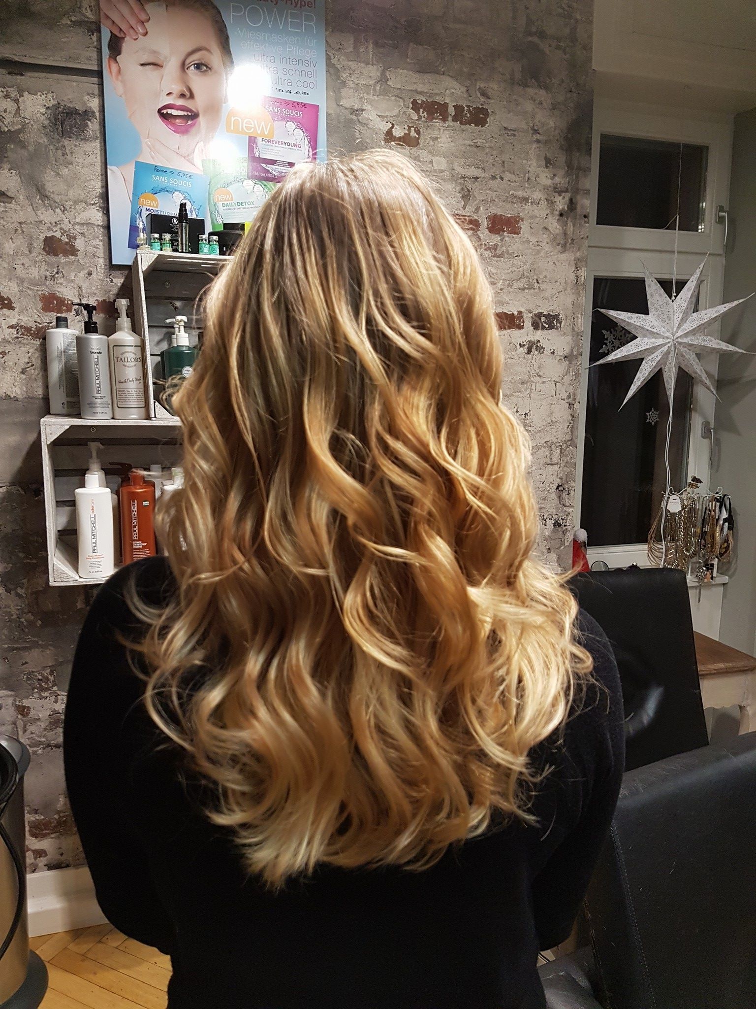 Eine Frau mit langen blonden Haaren steht in einem Raum.