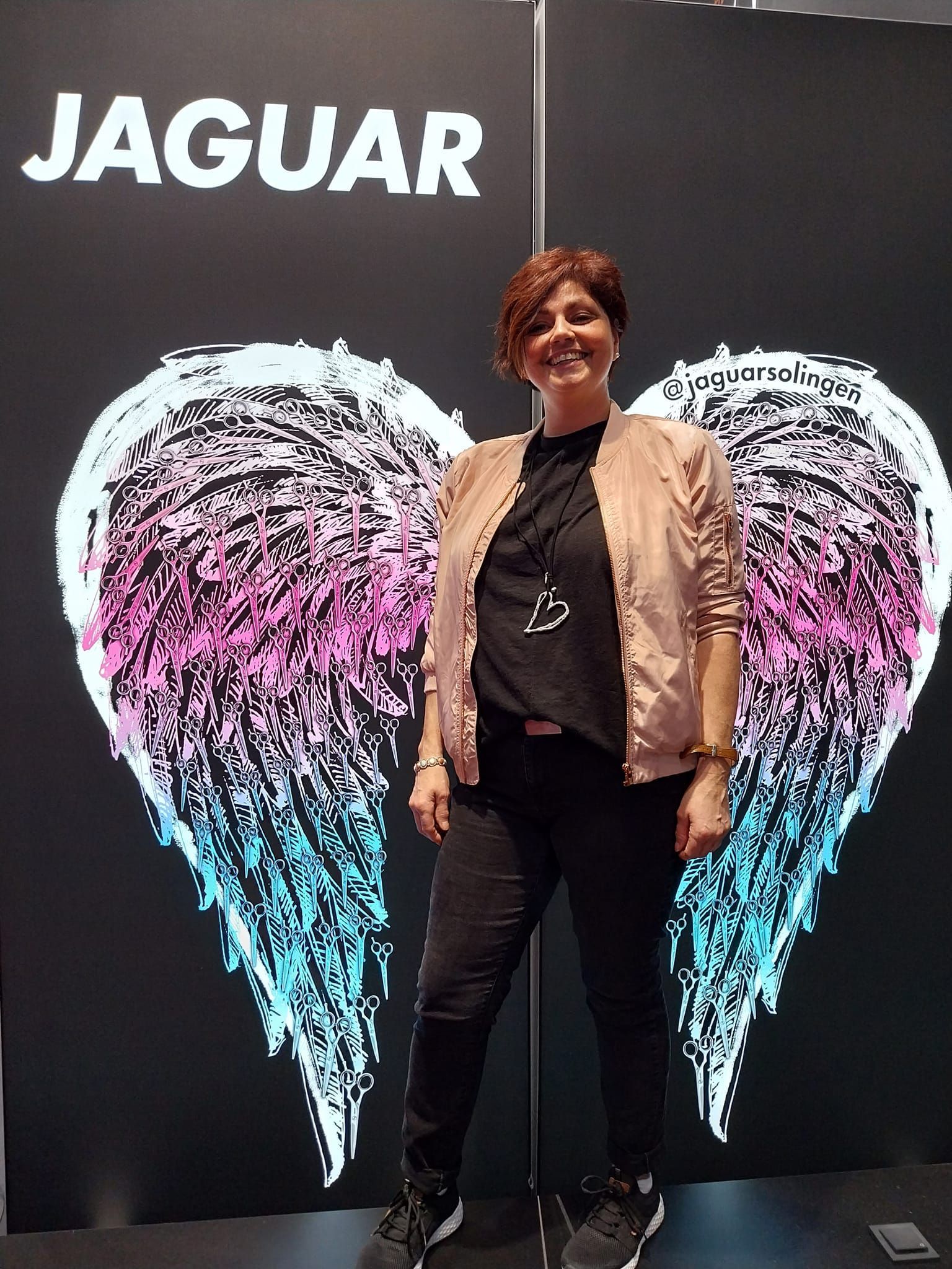 Eine Frau steht vor einem Schild mit der Aufschrift „Jaguar“