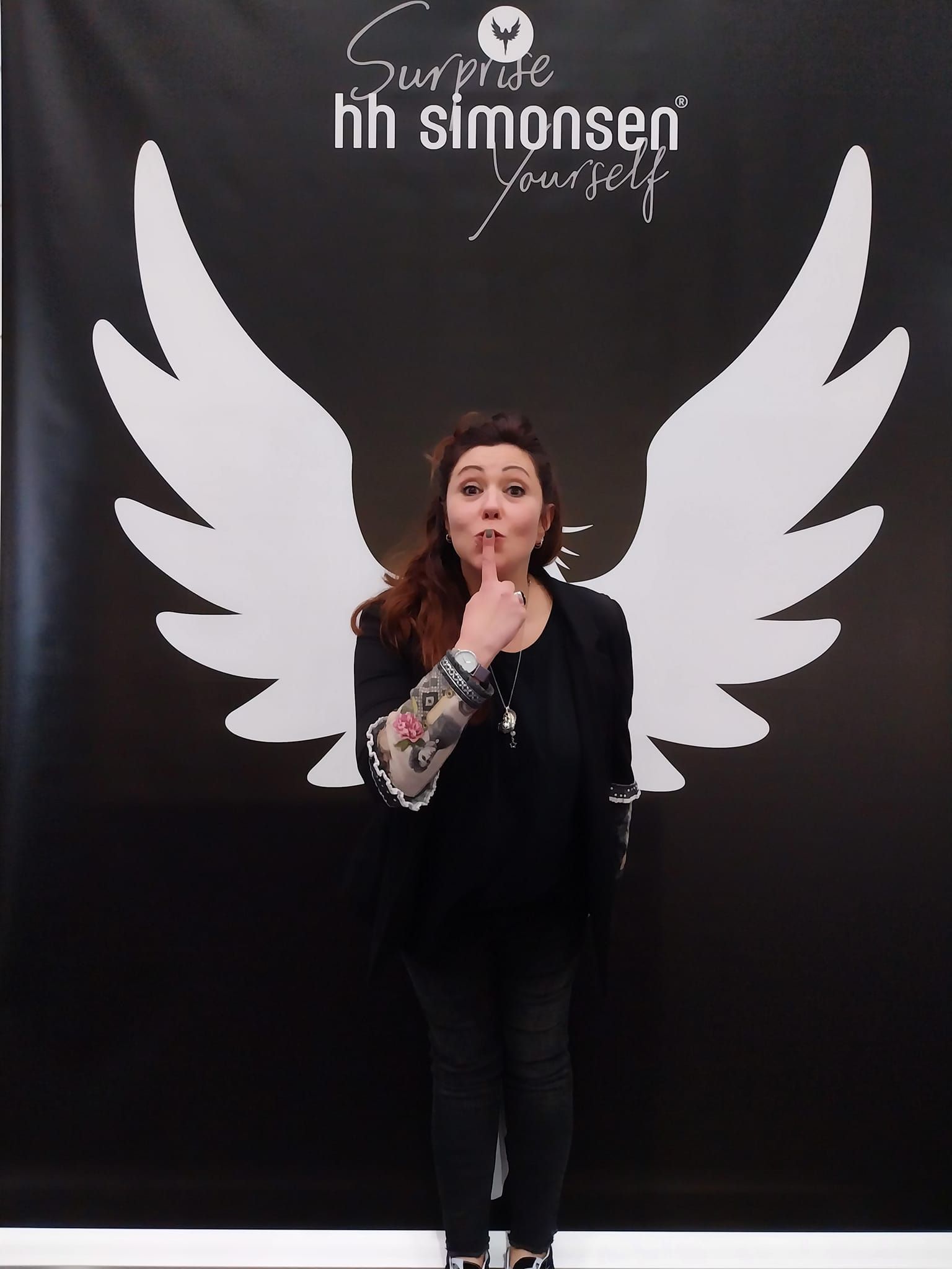 Eine Frau steht vor einem Schild mit der Aufschrift „Überrasche dich selbst mit Simonsen“