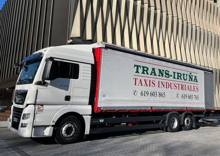 Camión de carga blanco con la inscripción “TRANS-IRUNÁ TAXIS INDUSTRIALS” 