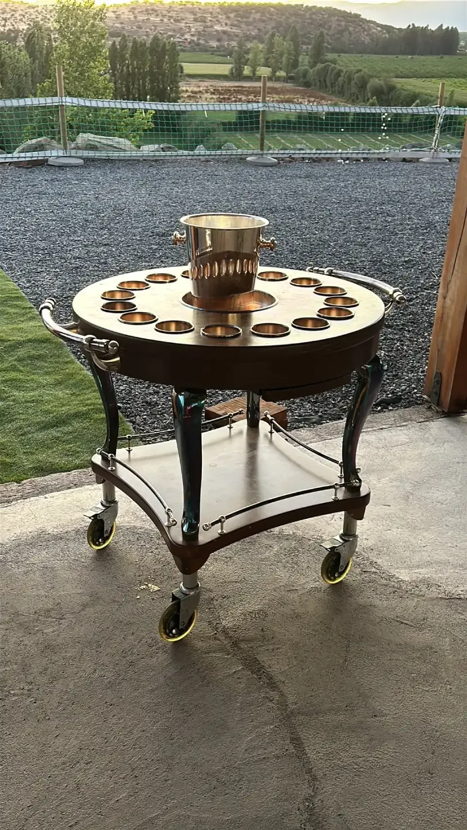 A wooden table with wheels and a bucket on top of it.