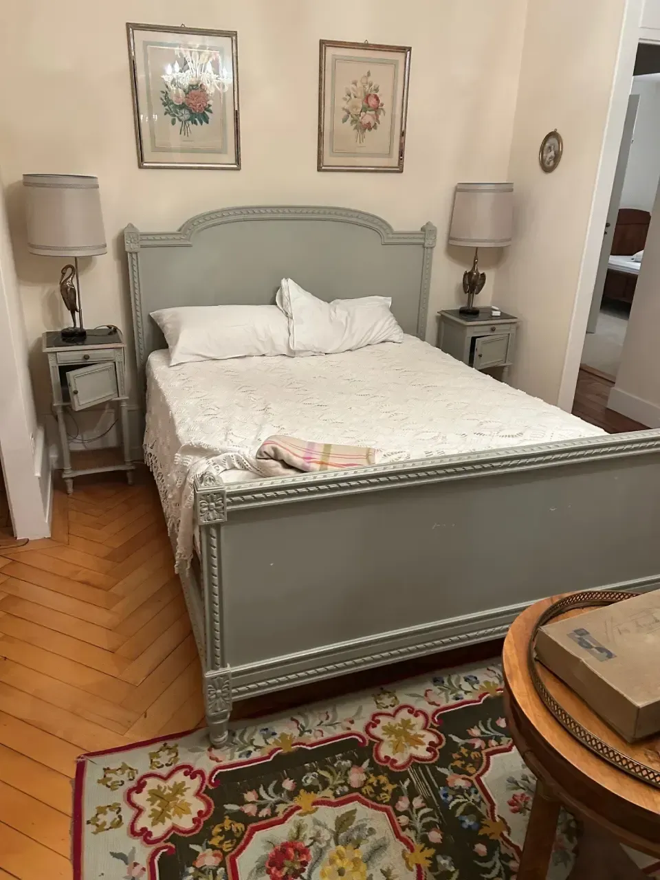 A bedroom with a bed , nightstands , lamps and a rug.