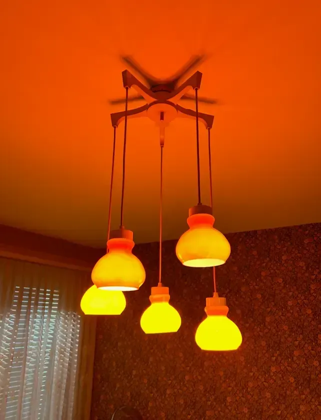 A bunch of yellow lights hanging from the ceiling