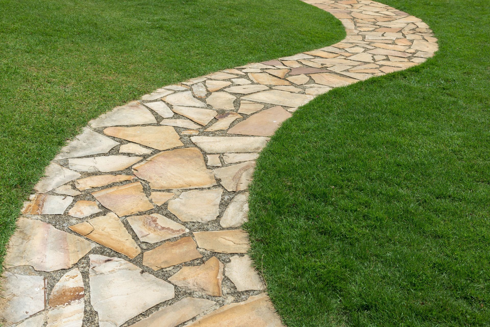 Chemin de pierre sur l'herbe verte dans le jardin 