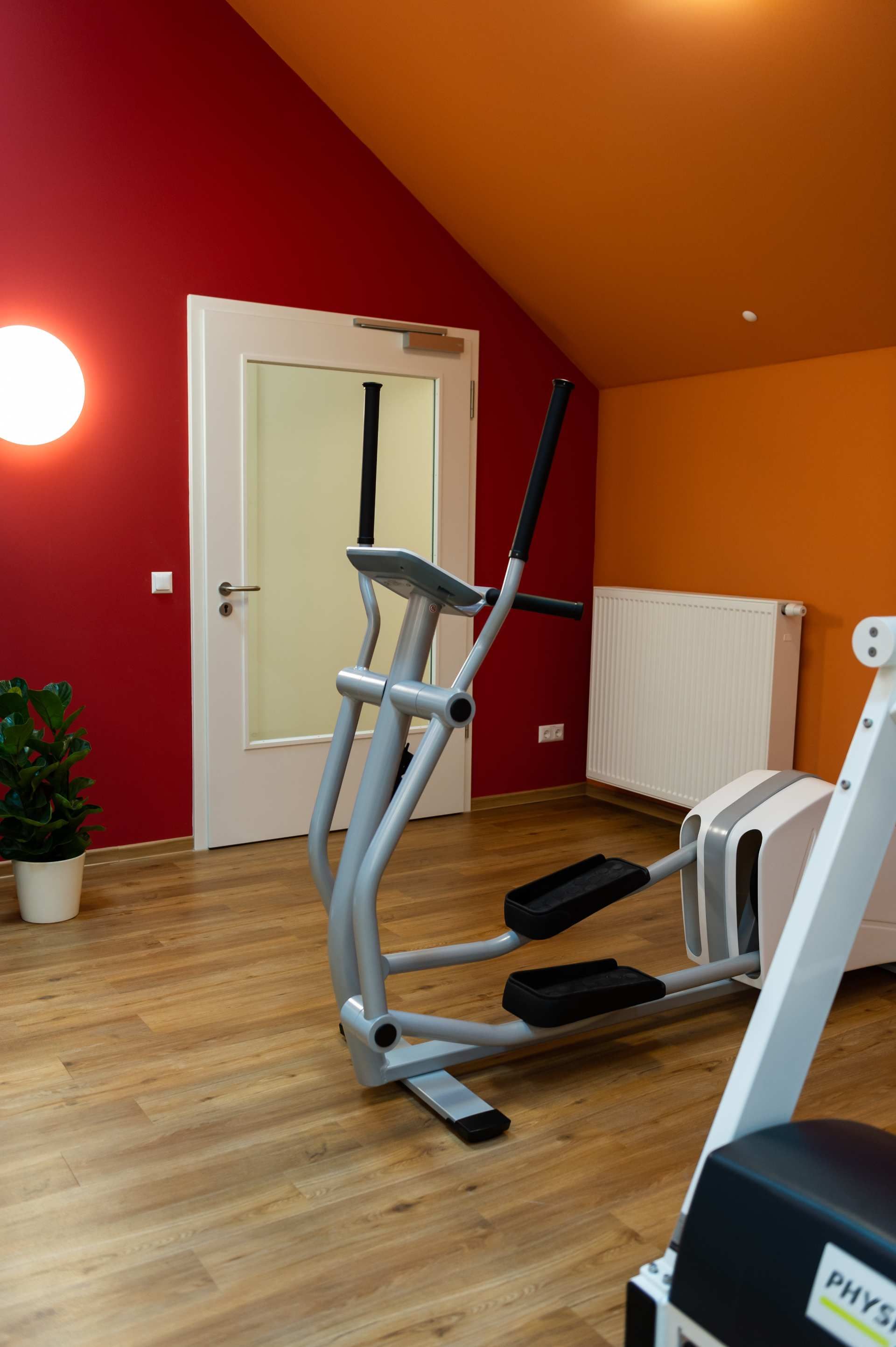 Raum mit oranger Decke und Wand, Tür und heller Beleuchtung.