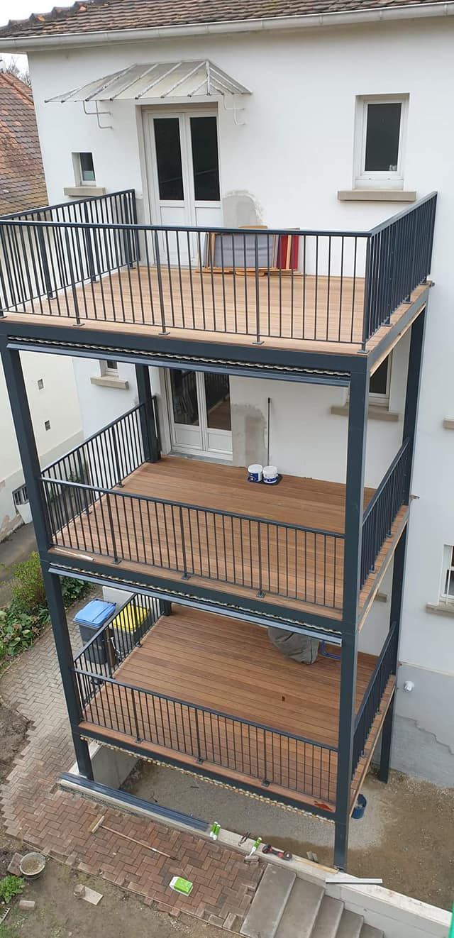 Terrasse en métal noir avec panneau de bois au sol