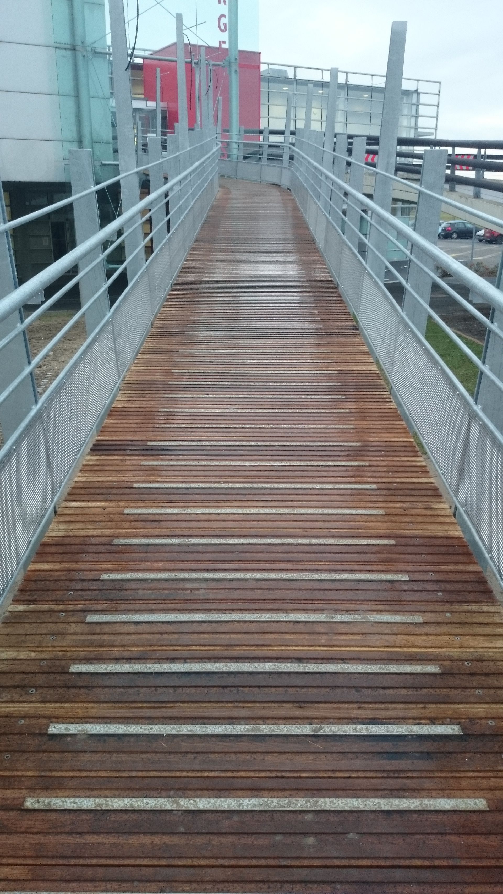 Rampe d'accès avec plancher en bois et garde-corps métallique