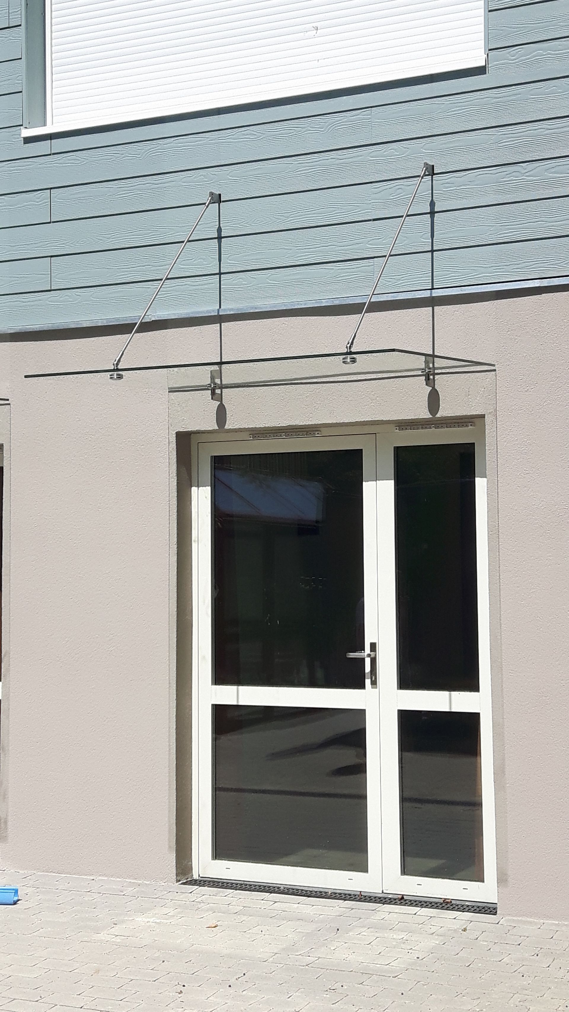 Marquise en verre au dessus d'une porte d'entrée