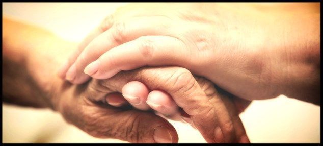 Kaksi kättä puristettu yhteen, mahdollisesti tarjoamalla lohtua tai tukea.