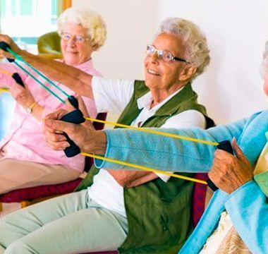 Un grupo de mujeres mayores están haciendo ejercicios con bandas de resistencia.