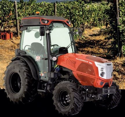 Tractor naranja y negro con neumáticos grandes, aislado sobre un fondo blanco.
