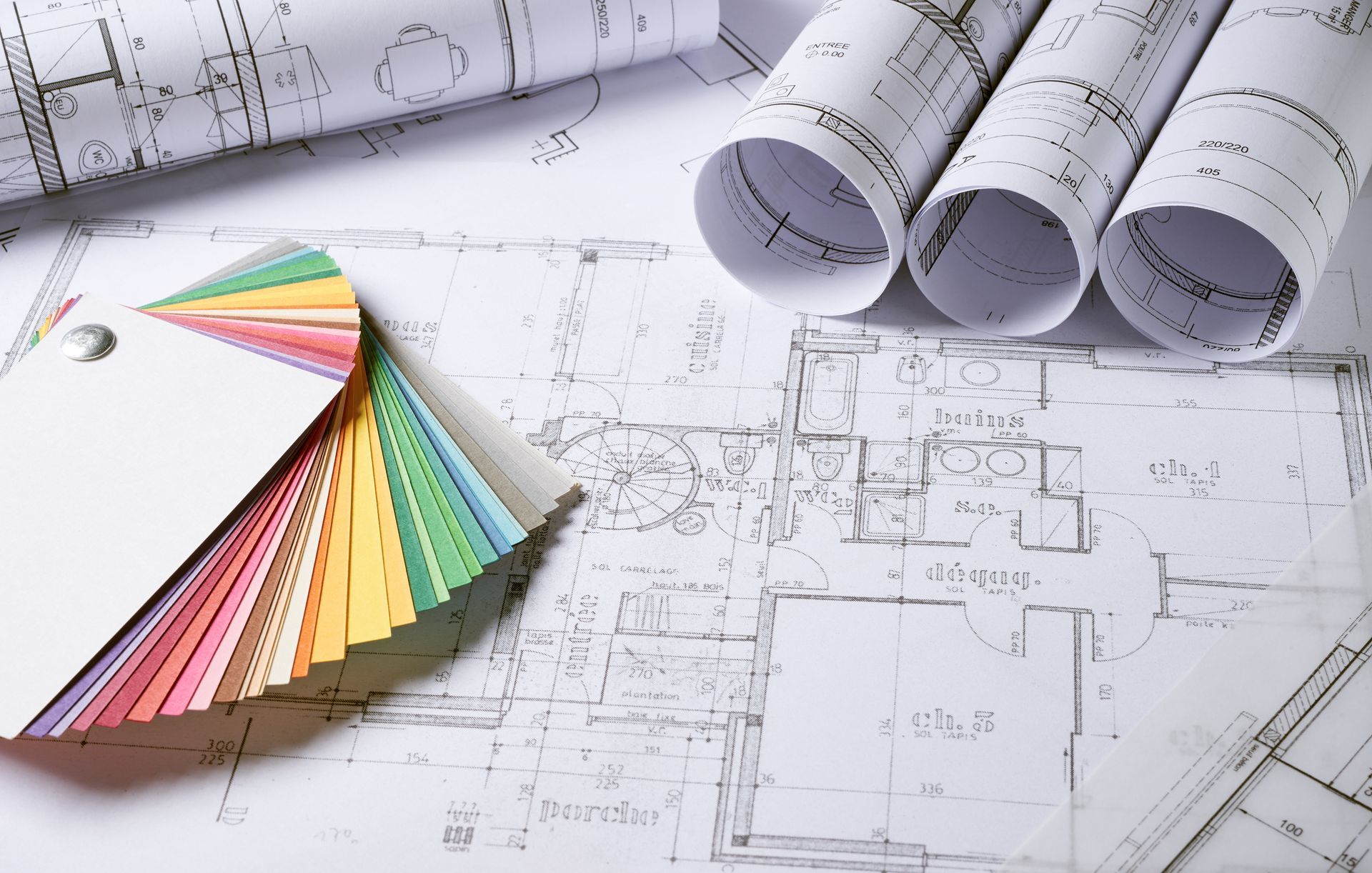 Échantillon coloré de peinture sur des plans architecturaux enroulés.