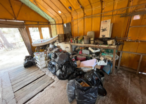 A garage filled with lots of trash bags and boxes