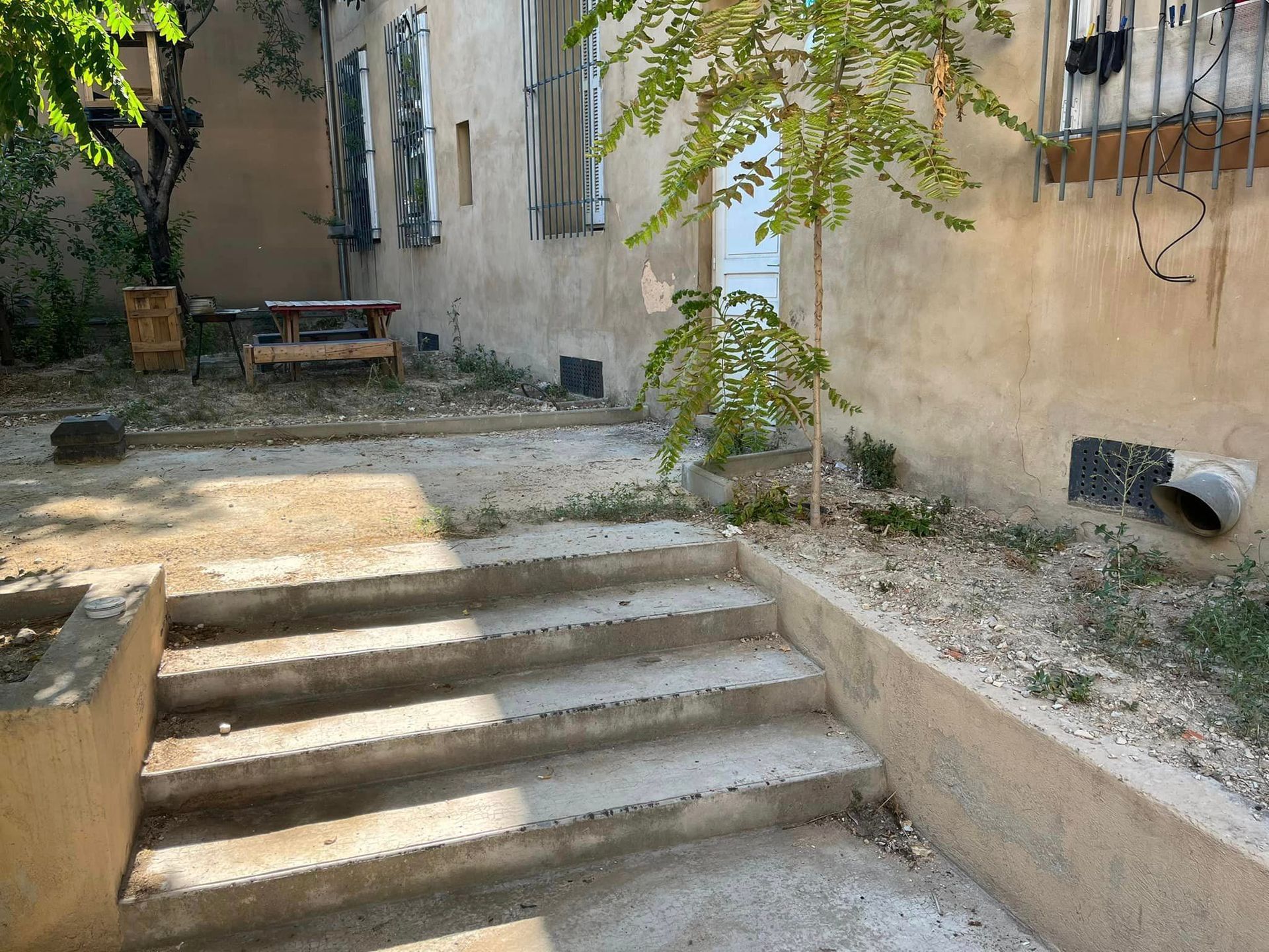 A set of stairs leading up to a building with a picnic table in the background.
