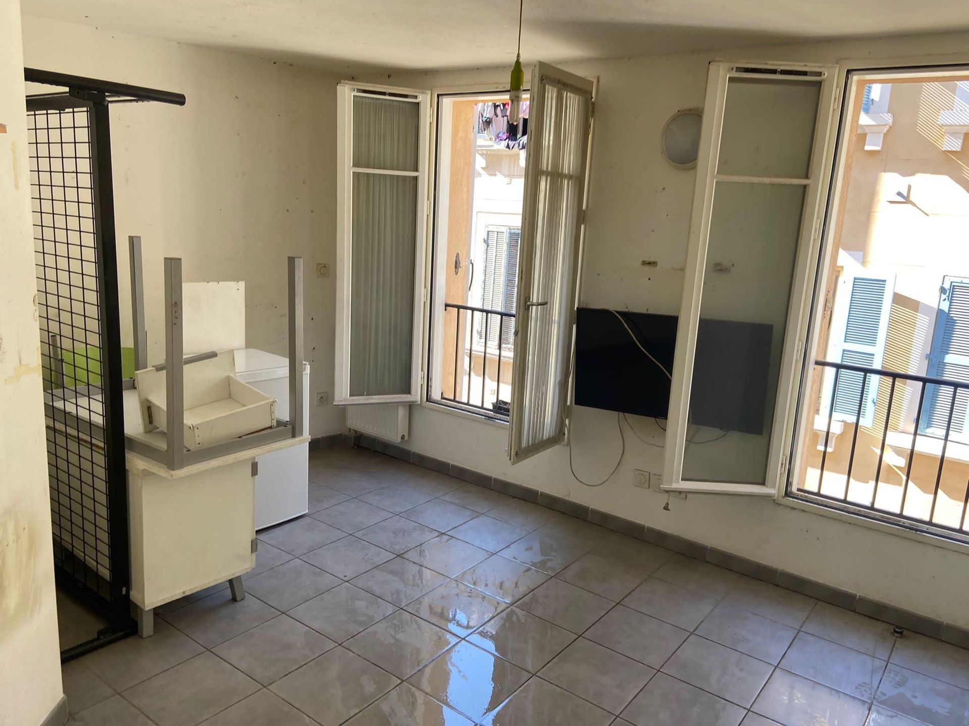 An empty room with a chair and a television on the wall.