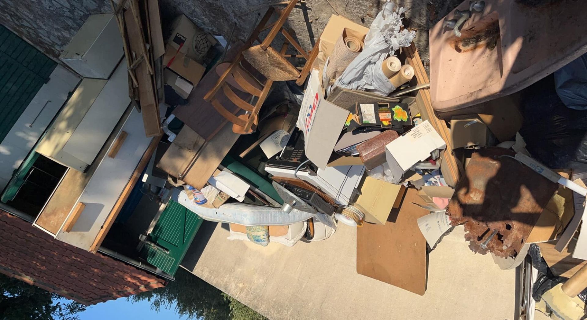 A pile of junk is sitting on the ground in front of a building.