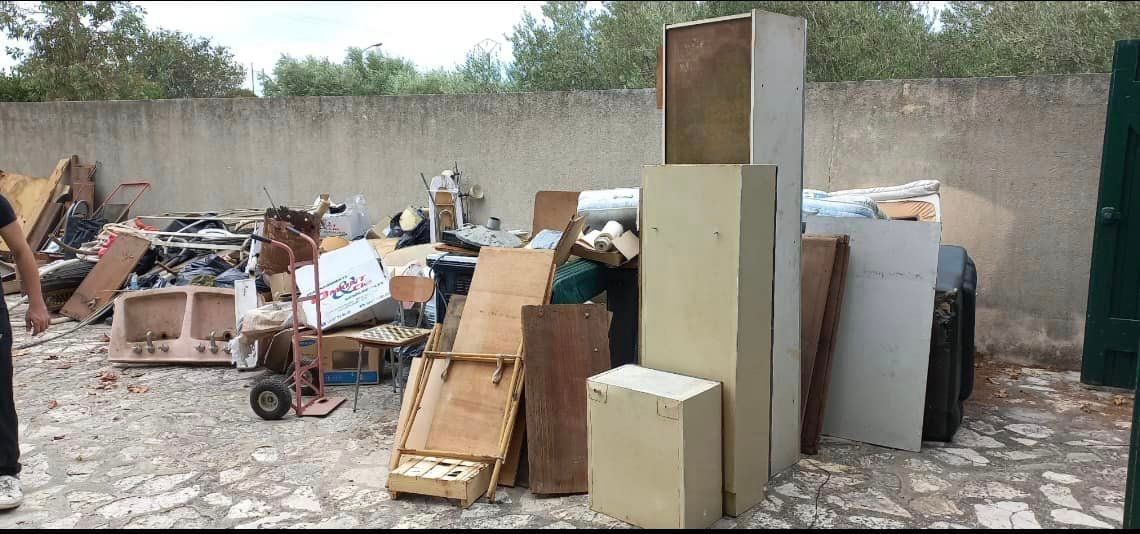 A pile of junk is sitting on the ground in front of a wall.
