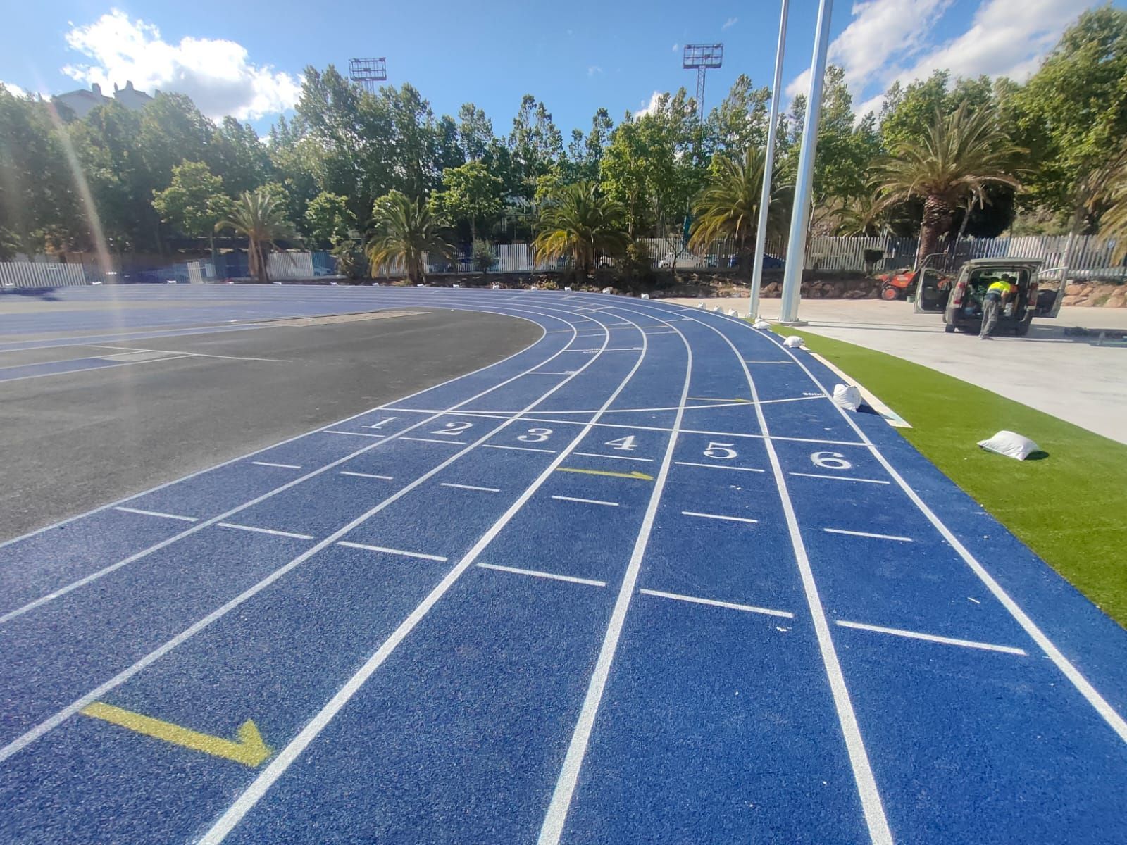 Una pista azul con líneas blancas y una flecha amarilla