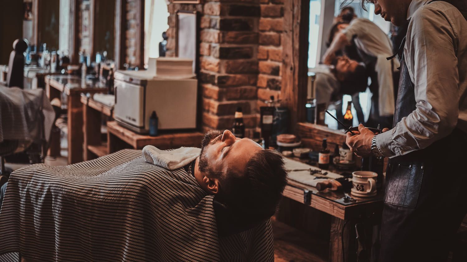 Un hombre se está afeitando la barba en una barbería.