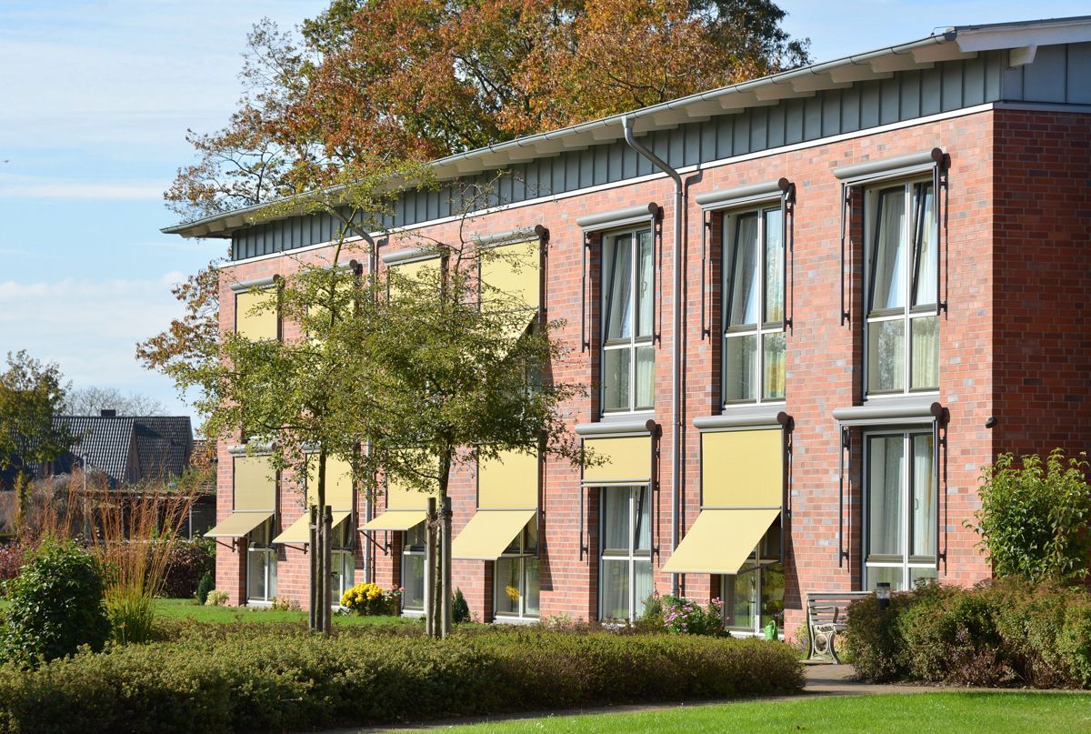 Ein Backsteingebäude mit gelben Markisen an den Fenstern