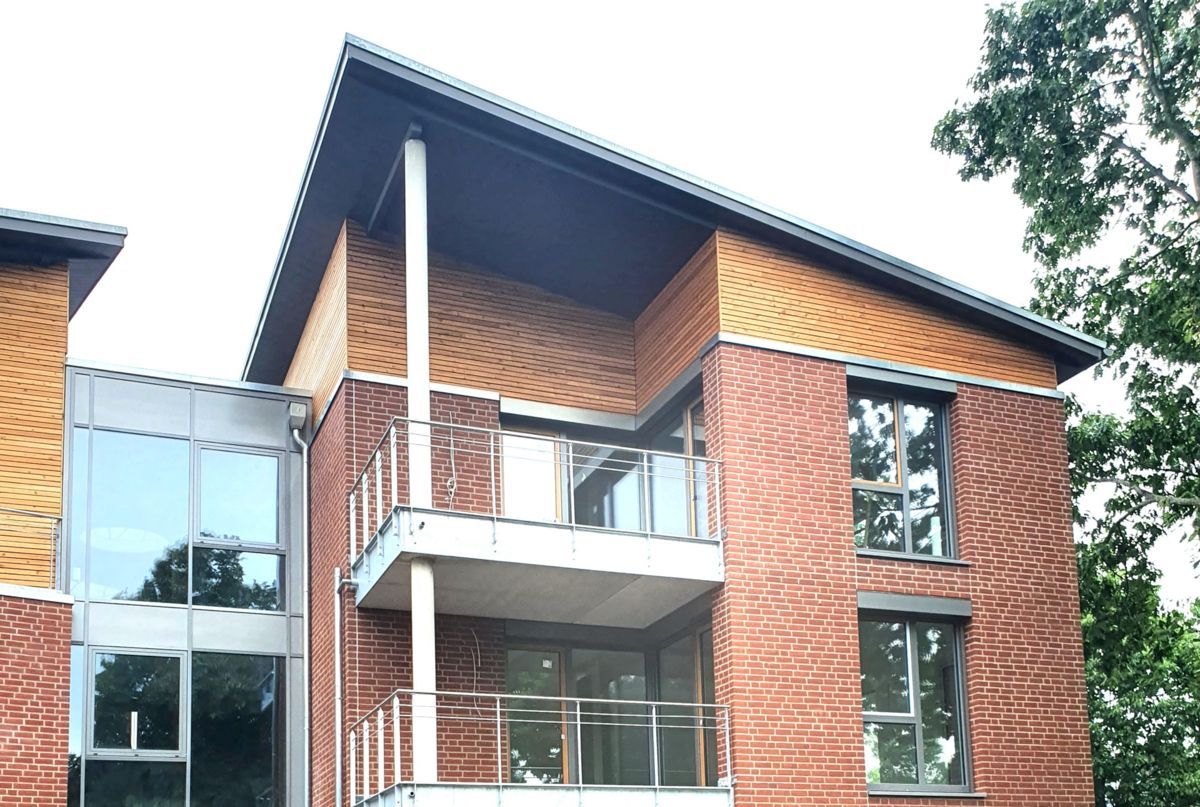 Ein großes Backsteingebäude mit Balkon und vielen Fenstern